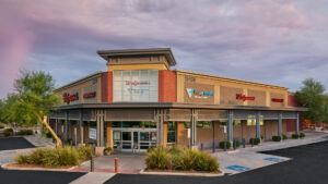 A Walgreens store in Florida shows a sign for VillageMD primary care on the side, along with a now open sign.